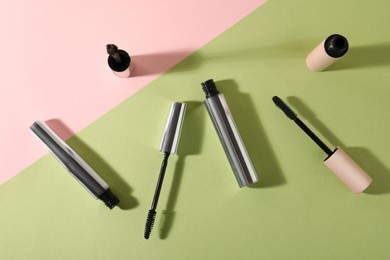 Different mascaras on color background, flat lay