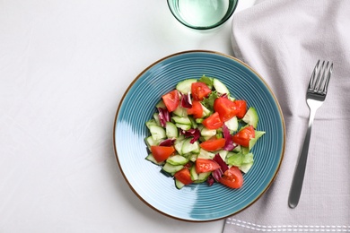 Flat lay composition with delicious fresh cucumber tomato salad on table, space for text