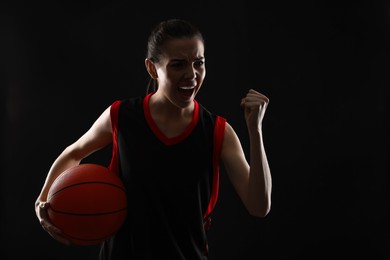 Photo of Basketball player with ball on black background