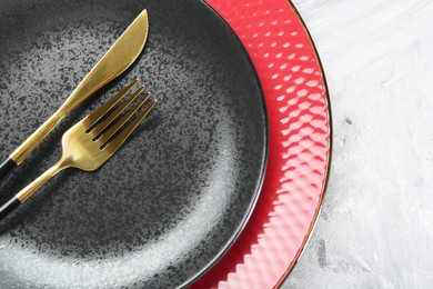 Photo of Clean plates and cutlery on gray table, top view. Space for text