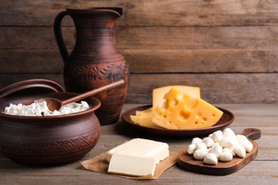 Composition with dairy products and clay dishware on wooden table