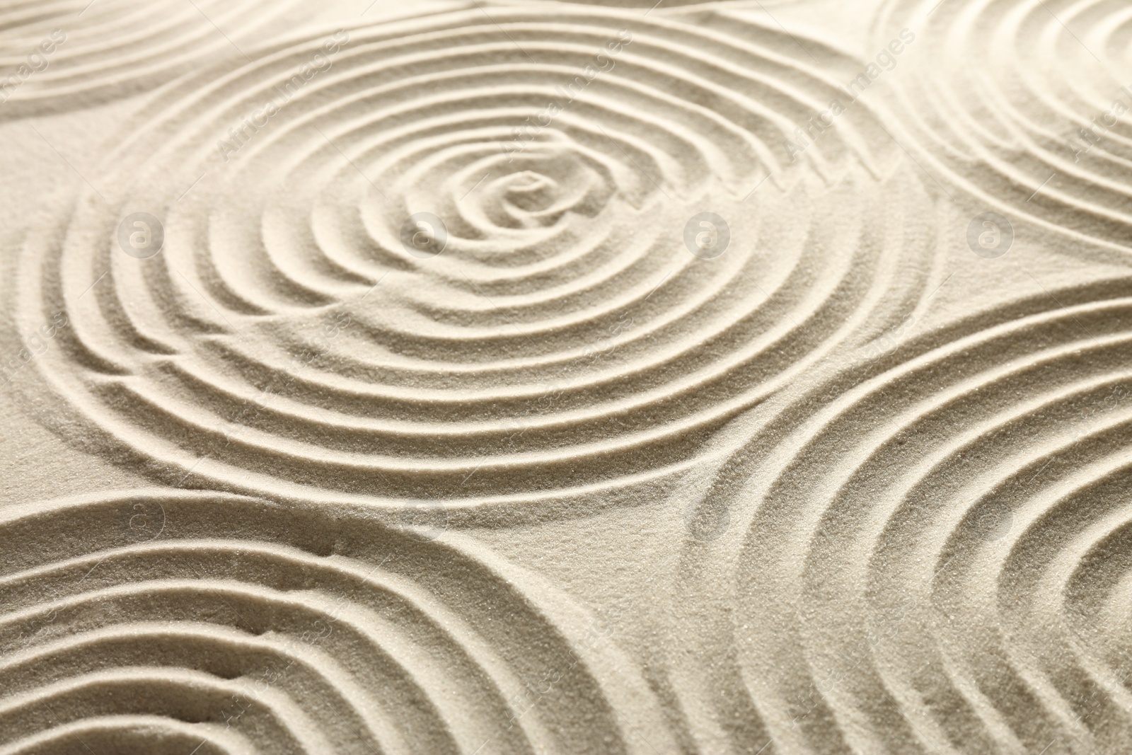 Photo of Beautiful spirals on sand, closeup. Zen garden