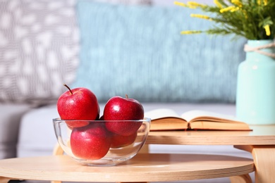 Bowl of fresh red apples on table indoors. Space for text