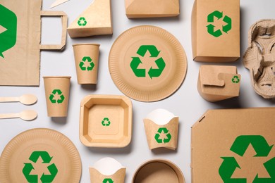Image of Set of eco friendly food packaging with recycling symbols on light background, flat lay
