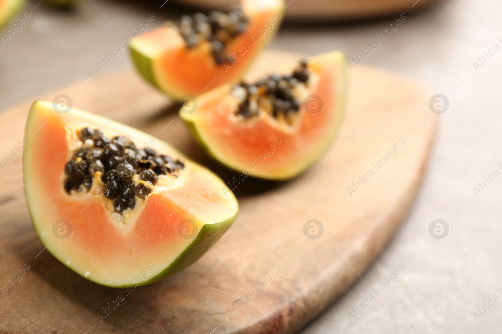 Photo of Fresh cut papaya on grey table, closeup. Space for text