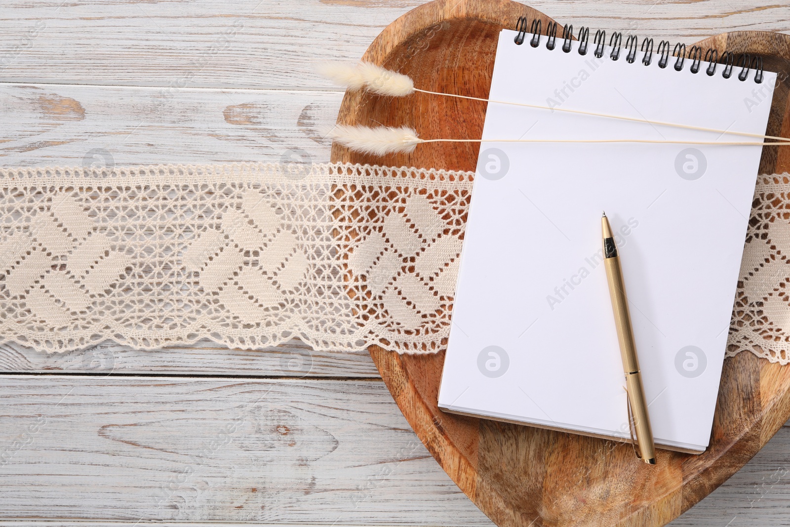 Photo of Guest list. Notebook, pen, spikelets and lace ribbon on wooden background, flat lay. Space for text