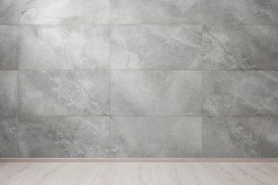 Photo of Empty room with grey marble wall and wooden floor