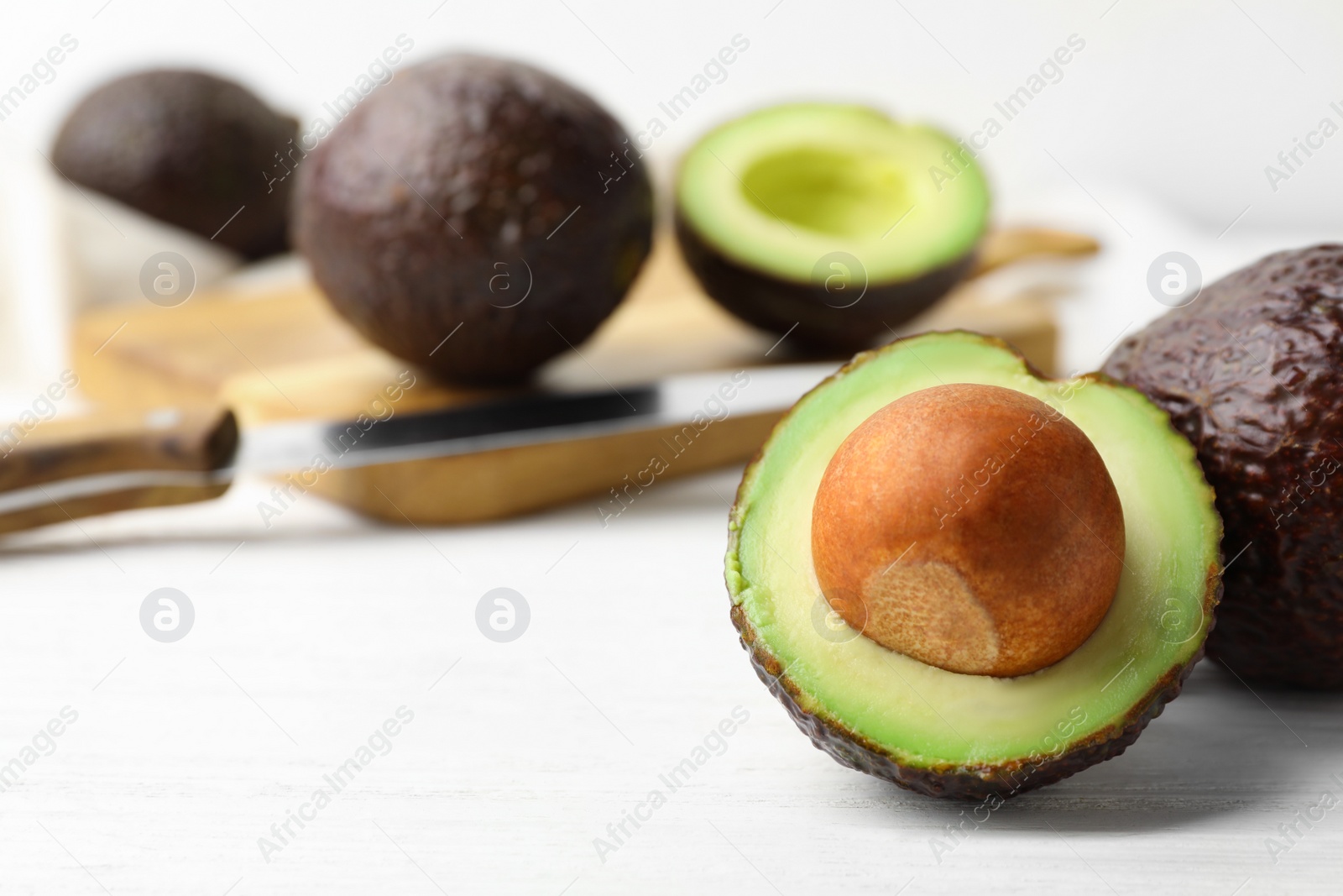 Photo of Delicious ripe avocados on white wooden table