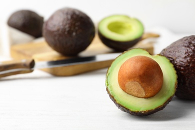 Photo of Delicious ripe avocados on white wooden table