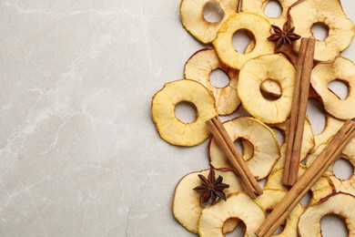 Delicious apple chips, anise and cinnamon on light grey table, flat lay. Space for text