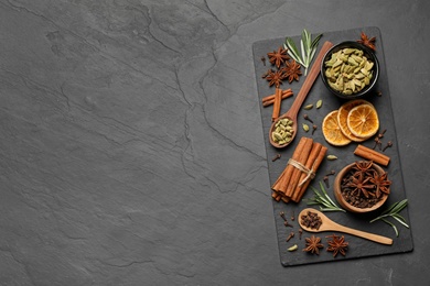 Photo of Flat lay composition with mulled wine ingredients on black slate table. Space for text