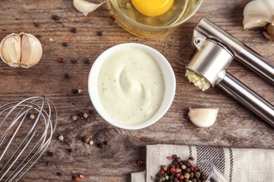 Photo of Flat lay composition with garlic sauce on wooden background