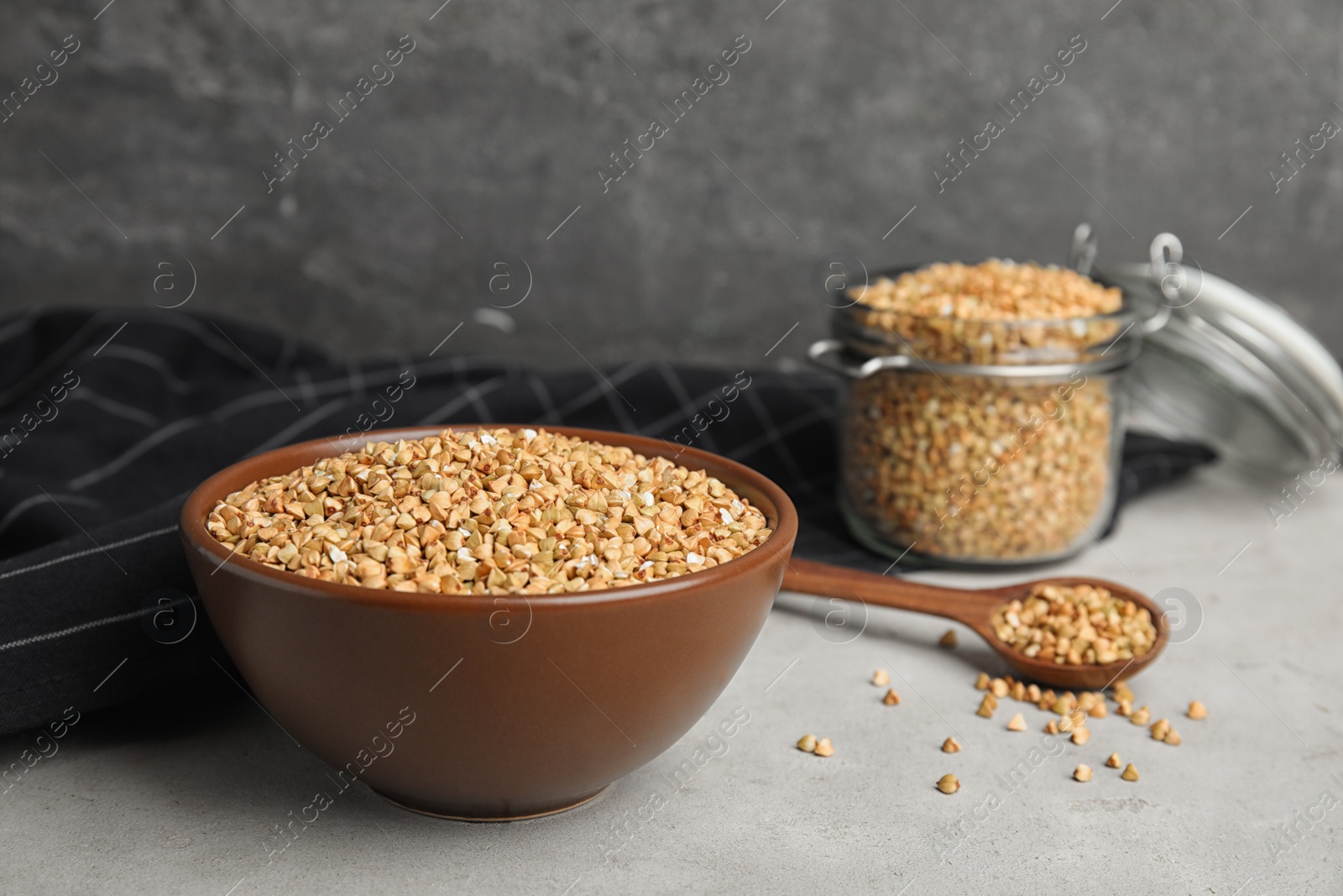 Photo of Uncooked green buckwheat grains in bowl on table