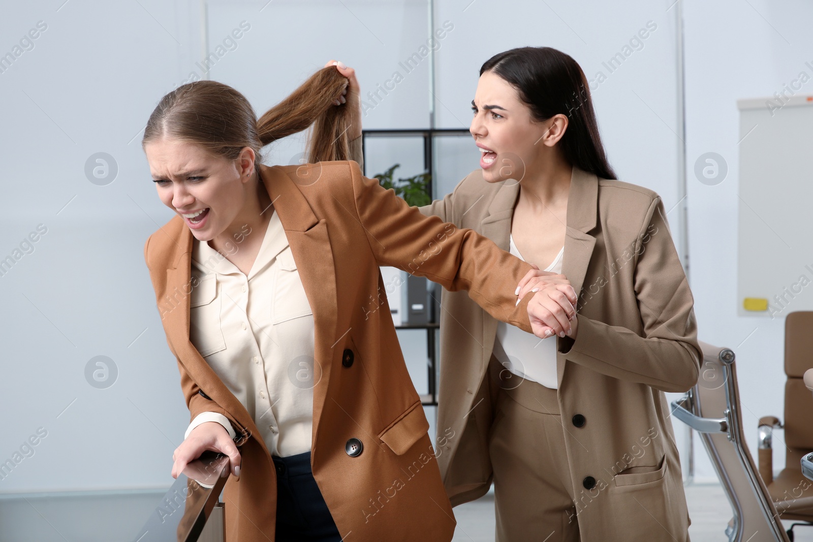 Photo of Emotional colleagues fighting in office. Workplace conflict