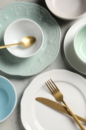 Photo of Beautiful ceramic dishware and cutlery on light grey table, flat lay
