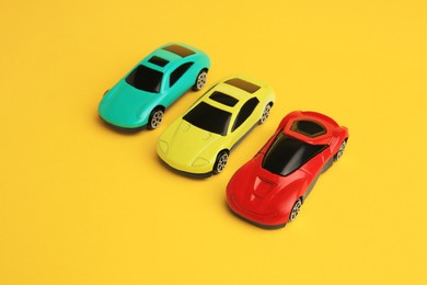 Photo of Different bright cars on yellow background. Children`s toys