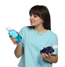 Young woman with different types of mouthwash on white background