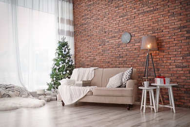 Photo of Decorated Christmas tree in stylish living room interior