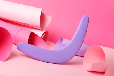 Photo of Creative composition with lilac wooden boomerang on color background