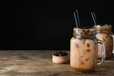 Photo of Tasty milk bubble tea on wooden table. Space for text