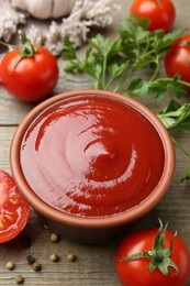 Photo of Tasty ketchup, fresh tomatoes, parsley and spices on wooden table