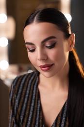 Beautiful woman wearing makeup in dressing room