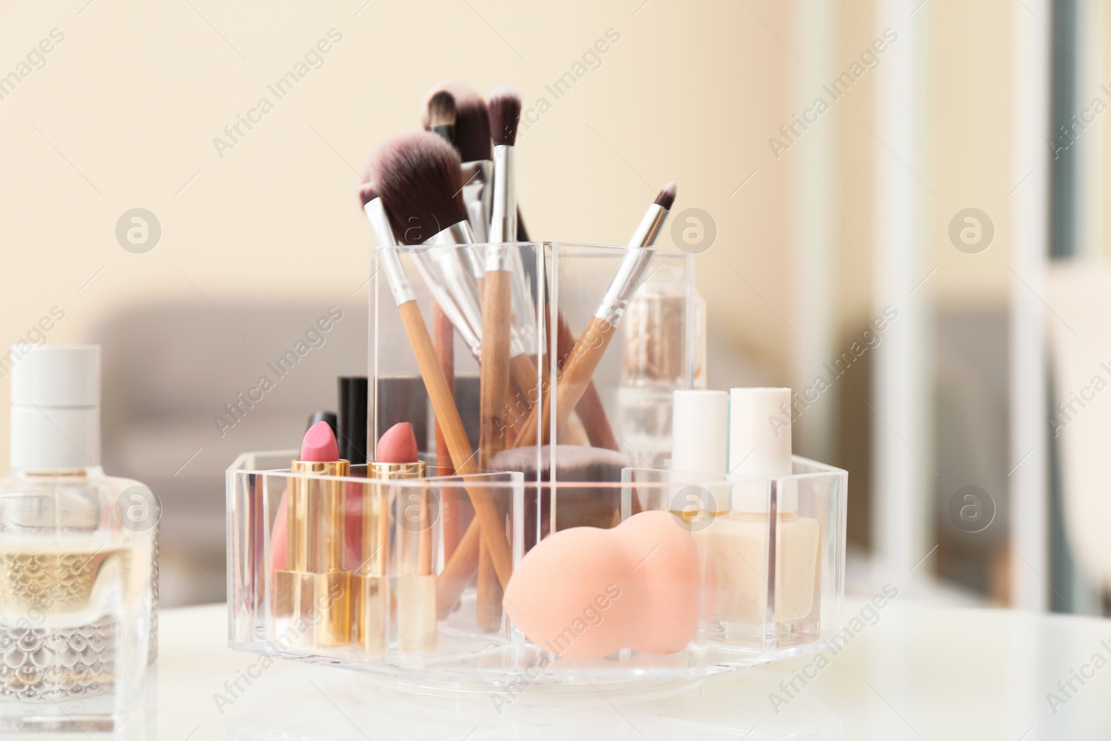 Photo of Organizer with cosmetic products for makeup on table indoors