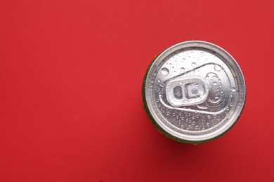 Photo of Energy drink in wet can on red background, top view. Space for text