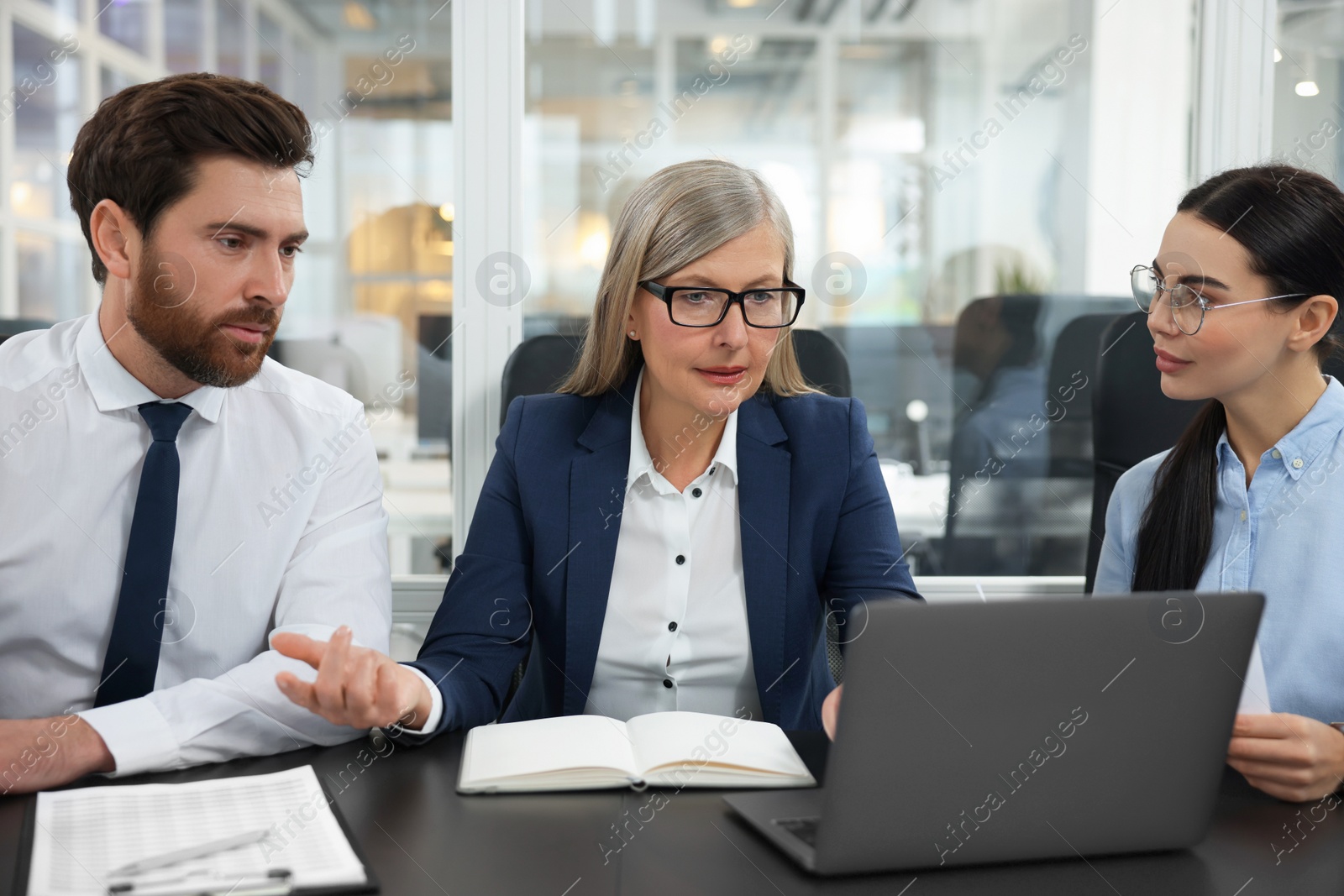 Photo of Lawyers working together with laptop at table in office