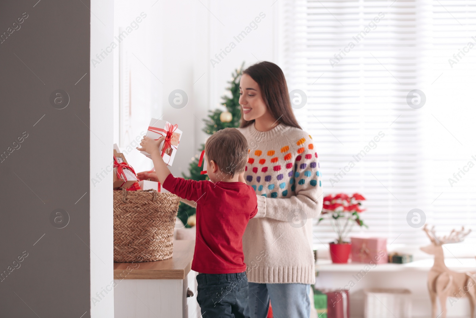 Photo of Mother and son with Christmas gifts at home. Advent calendar in basket