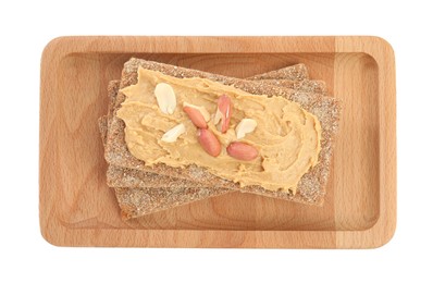 Photo of Fresh rye crispbreads with peanut butter on white background, top view