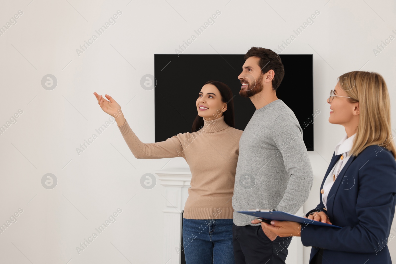 Photo of Real estate agent showing new apartment to couple