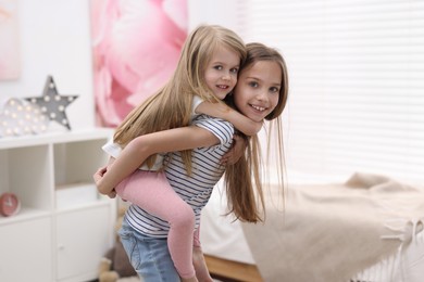 Photo of Cute little sisters having fun together at home