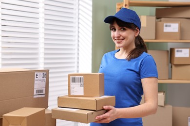 Parcel packing. Post office worker with parcels at wooden table indoors