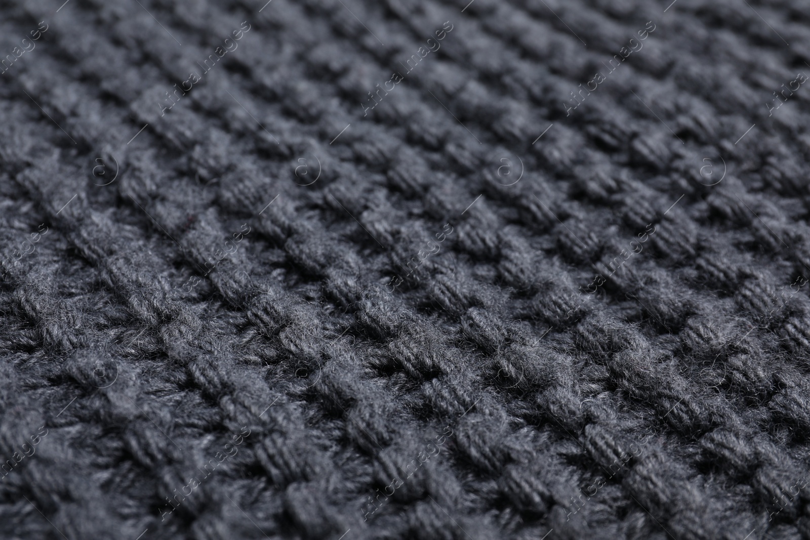 Photo of Gray knitted scarf as background, closeup view