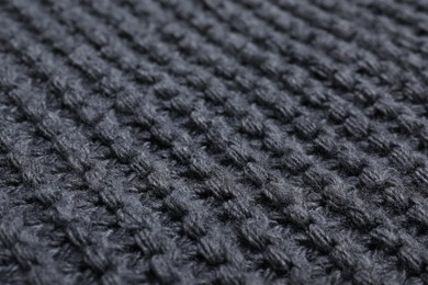 Photo of Gray knitted scarf as background, closeup view