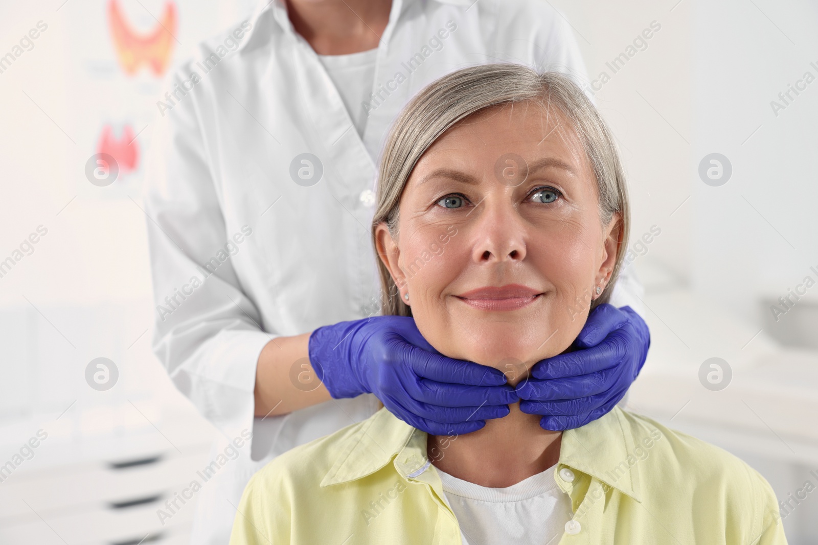 Photo of Endocrinologist examining thyroid gland of patient at hospital, closeup