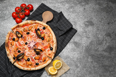 Photo of Tasty pizza with seafood and ingredients on grey table, flat lay. Space for text