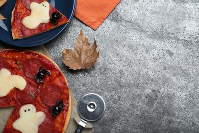 Cute Halloween pizza with ghosts and spiders served on grey table, flat lay. Space for text