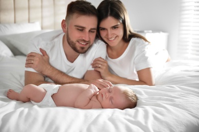 Happy couple with their newborn baby at home