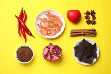 Photo of Natural aphrodisiac. Different products and heart model on yellow background, flat lay