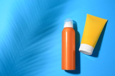 Photo of Sunscreens on light blue background, flat lay and space for text. Sun protection care
