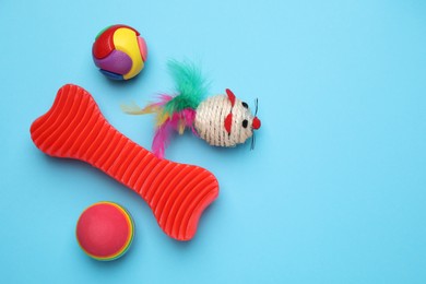 Different pet toys on light blue background, flat lay. Space for text