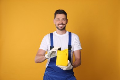 Photo of Man holding yellow container of motor oil on orange background