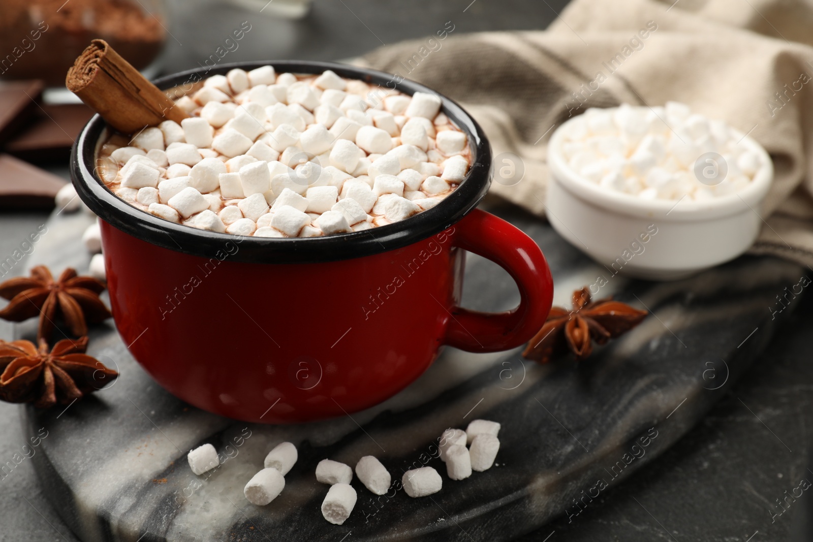 Photo of Tasty hot chocolate with marshmallows on dark textured table, closeup