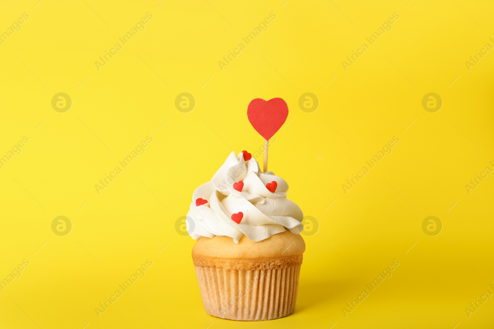 Photo of Tasty cupcake for Valentine's Day on yellow background