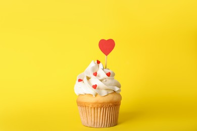 Photo of Tasty cupcake for Valentine's Day on yellow background