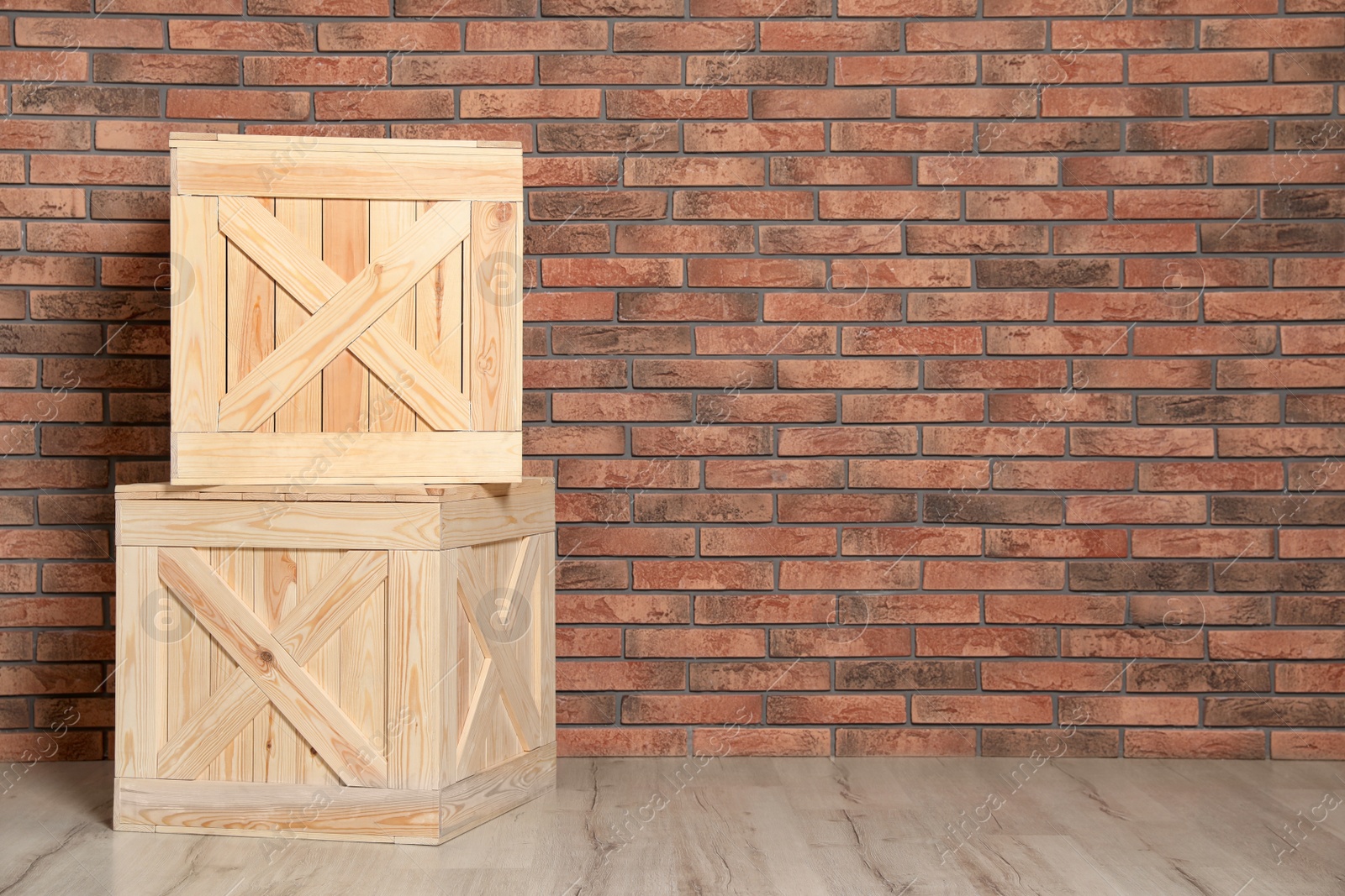 Photo of Wooden crates on floor at brick wall. Space for text