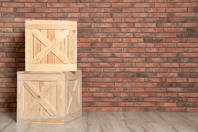 Photo of Wooden crates on floor at brick wall. Space for text