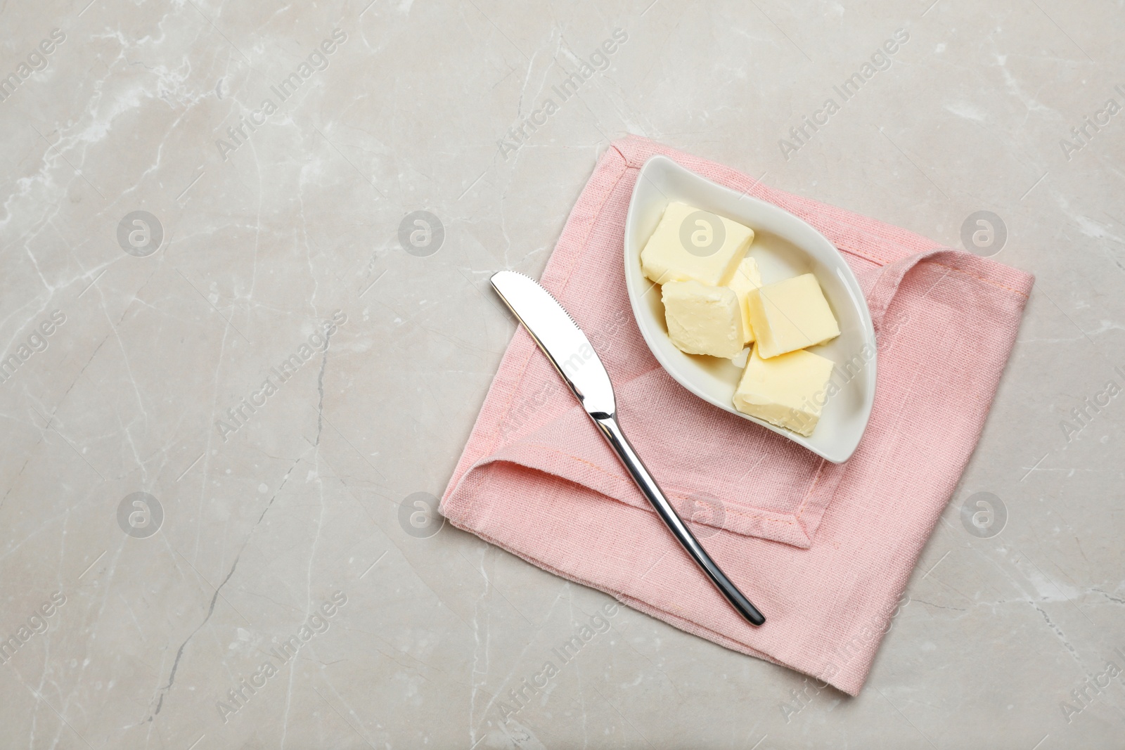 Photo of Plate with tasty fresh butter and knife on table, top view